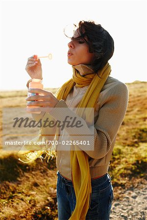 Woman Blowing Bubbles Outdoors