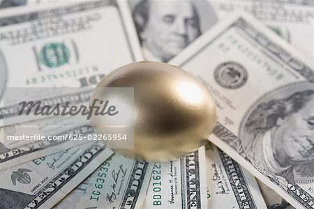 Close-up of a golden egg on US paper currency