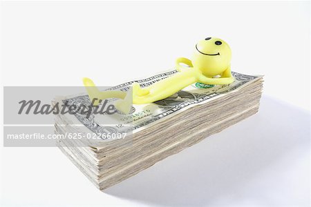 Figurine d'un homme couché sur une liasse de billets d'un dollar US