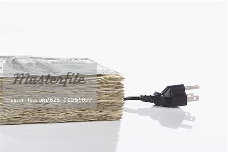 Bundle of US paper currency with a three pin plug