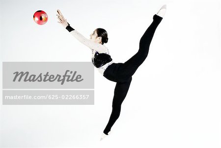 Seitenansicht des ein weiblicher Gymnast üben mit einem ball