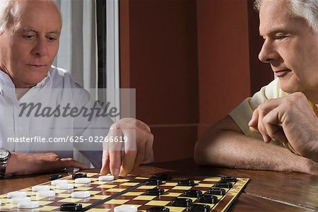 Two senior men playing checkers