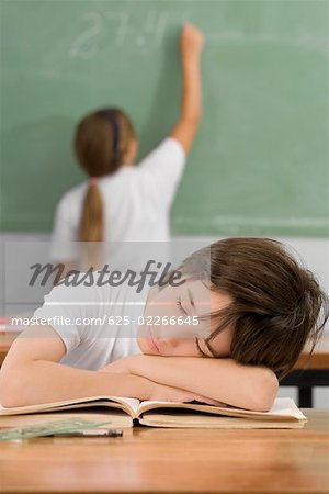 Schoolboy napping on a desk in a classroom