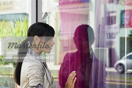 Profil de côté d'une jeune femme lèche-vitrine