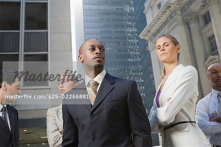 Zwei Geschäftsfrauen mit drei Geschäftsmänner stehend