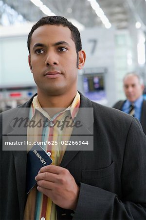 Close-up of a businessman putting a passport in his coat's pocket
