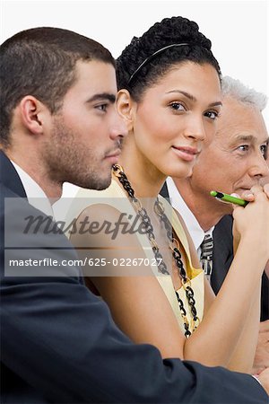 Two businessmen and a businesswoman at a meeting in a conference room