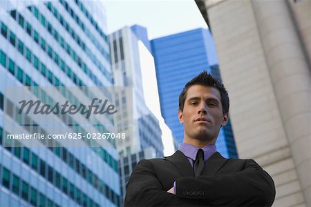 Low angle view of a businessman standing with his arms crossed