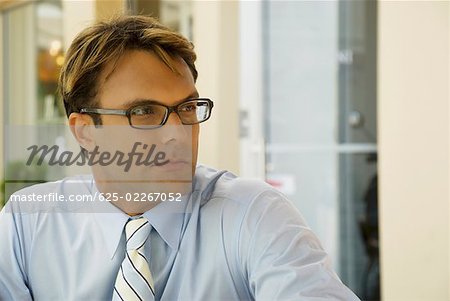 Close-up of a businessman wearing eyeglasses and thinking