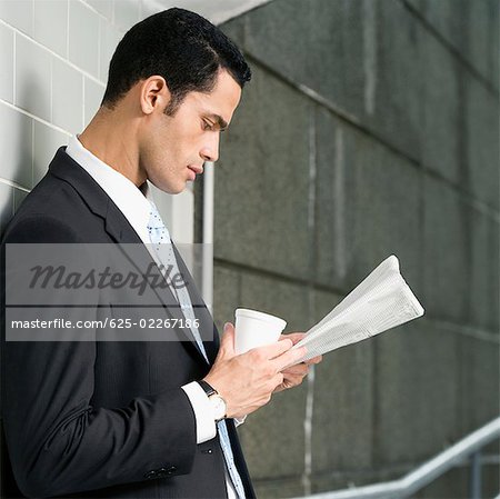 Profil de côté d'un homme d'affaires, lire un journal