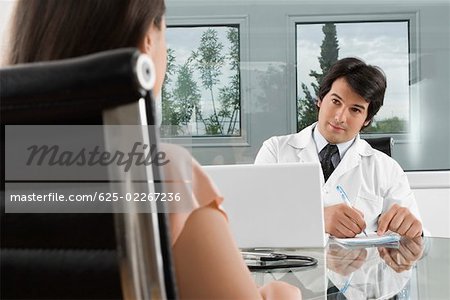 Male doctor sitting with a patient in a clinic