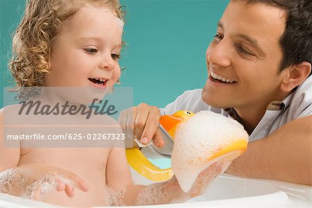 Close-up of a mid adult man looking at his daughter and smiling