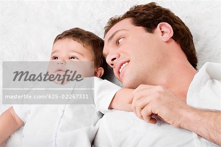 Nahaufnahme eines jungen Mannes, der mit seinem Sohn liegend