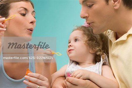 Close-up of a mid adult couple looking at their daughter