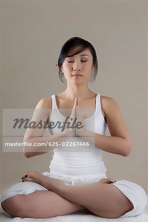 Jeune femme assise dans une position de prière