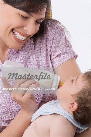 Close-up of a mid adult woman feeding her son with a baby bottle