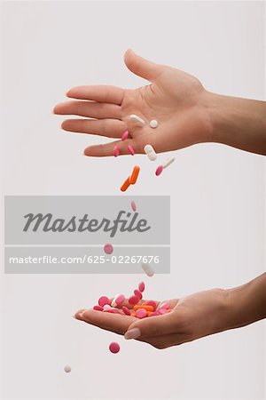 Close-up of a person's hand pouring pills on another hand