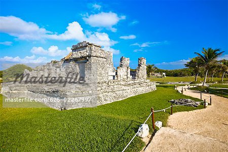 Alte Ruinen eines Palastes in einem grünen Feld, Zona Arqueologica De Tulum-Cancun, Quintana Roo, Mexiko