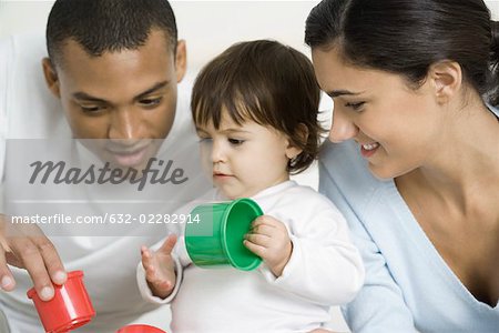 Parents et enfant en bas âge jeune fille jouant avec des jouets ensemble