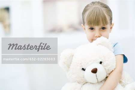 Little girl holding teddy bear, portrait