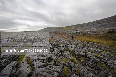 Frau Wandern über Feld, Slieve Rua, Burren Nationalpark, County Clare, Irland