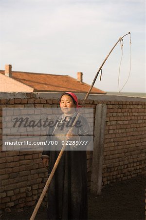 Femme avec Lasso pôle de l'écurie, la Mongolie intérieure, Chine