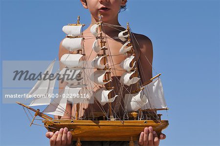 Garçon tenant la maquette de navire