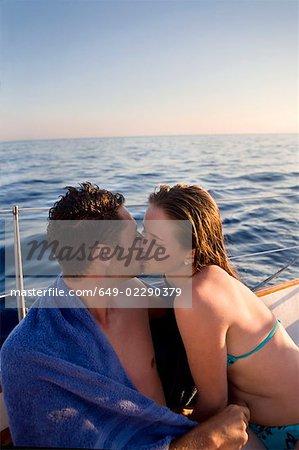 Young couple kissing on sailboat