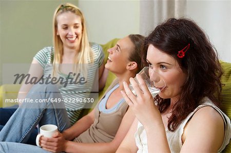 Drei junge Frauen sitzen auf der couch