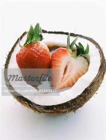 Strawberries and melted chocolate in a coconut shell
