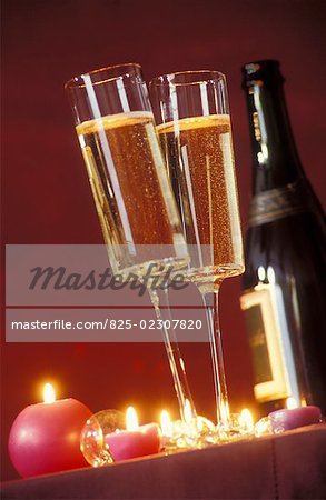 Filled champagne glasses by candlelight