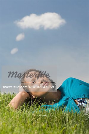 Woman lying on grass thinking