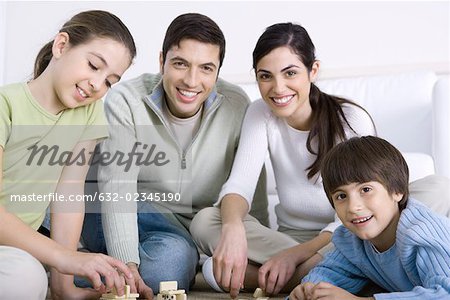 Family playing dominoes together, smiling