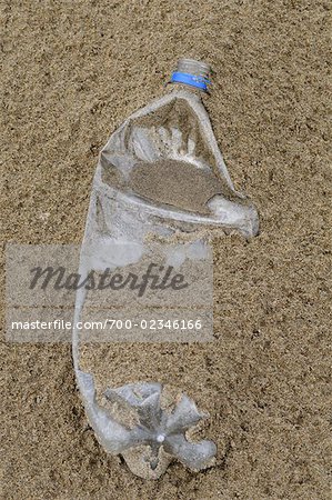 Gros plan d'une bouteille en plastique sur la plage