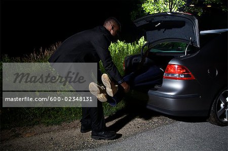 Placer le corps dans le coffre de la voiture de l'homme