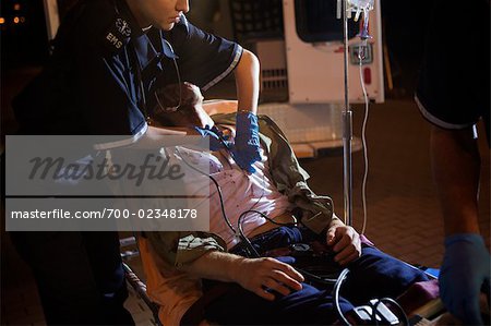Paramedic with Injured Man by Ambulance, Toronto, Ontario, Canada