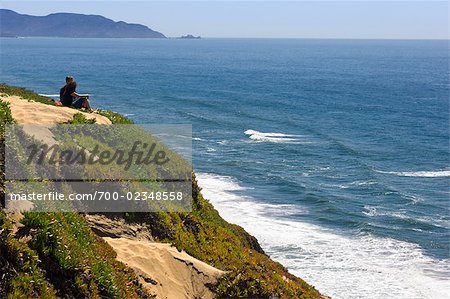 Paar, sitzen auf der Klippe mit Blick auf Ozean, Fort Funston, San Francisco, Kalifornien, USA