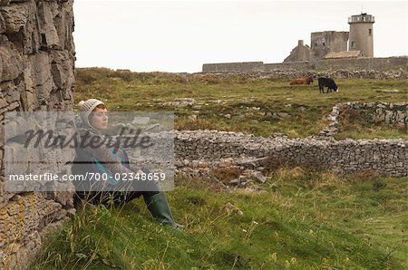 Femme adossée à Dun Eochla Fort, Dun parc Arann, Inishmor, îles d'Aran, comté de Galway, Irlande