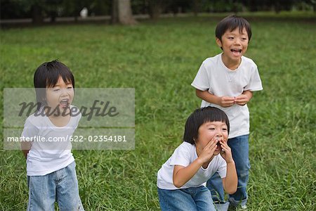 Lächelnde Kinder im Park stehen und schreien zusammen