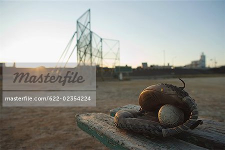 Baseball glove with ball in wooden bench