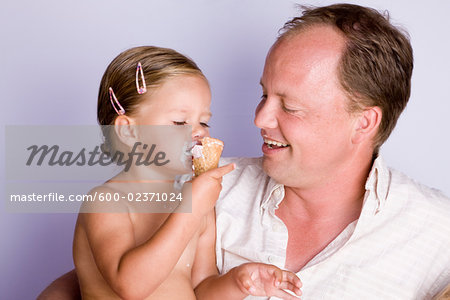 Father Watching Daughter Eat Ice Cream Cone