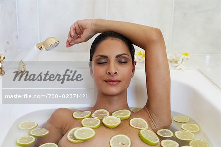 Femme dans la baignoire avec des tranches de citron