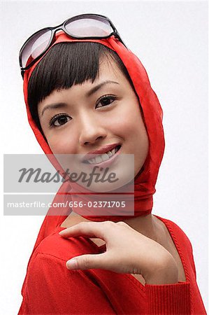 Portrait de femme portant des lunettes de soleil, écharpe et pull rouge