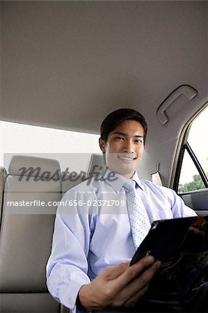 Homme d'affaires dans la banquette arrière de voiture