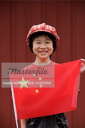 Portrait de petite fille debout derrière le drapeau chinois