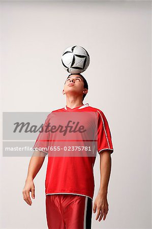 Fußballspieler mit Ball auf Kopf