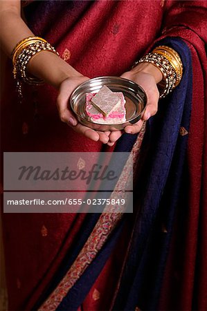Femme indienne offrant bonbons