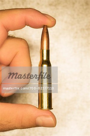 Man Holding 12.7mm Bullet