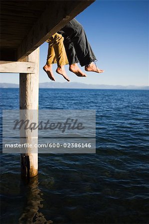 Femmes balançant pieds du quai sur le lac
