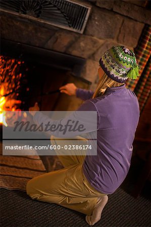 Femme attisant un feu